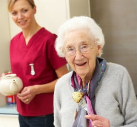 Elderly lady enjoying her meal while the SLP who specializes in the swallow study for dysphagia observes closely.