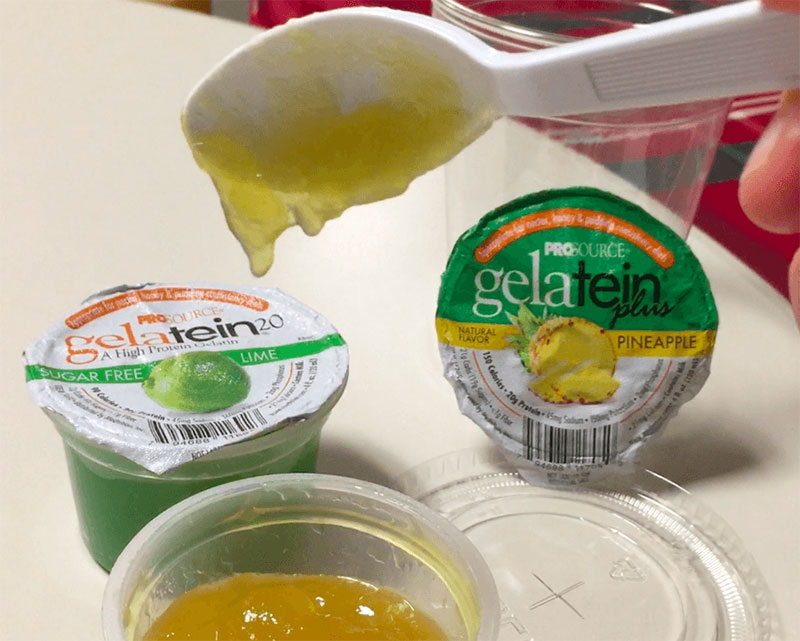 Picture of Gelatein product by Medtrition, Inc. Pineapple and Lime flavors shown. Image shows the product passing the spoon tilt test, sliding off the spoon. The slippery, yet thick substance could make a good dysphagia training jelly. 